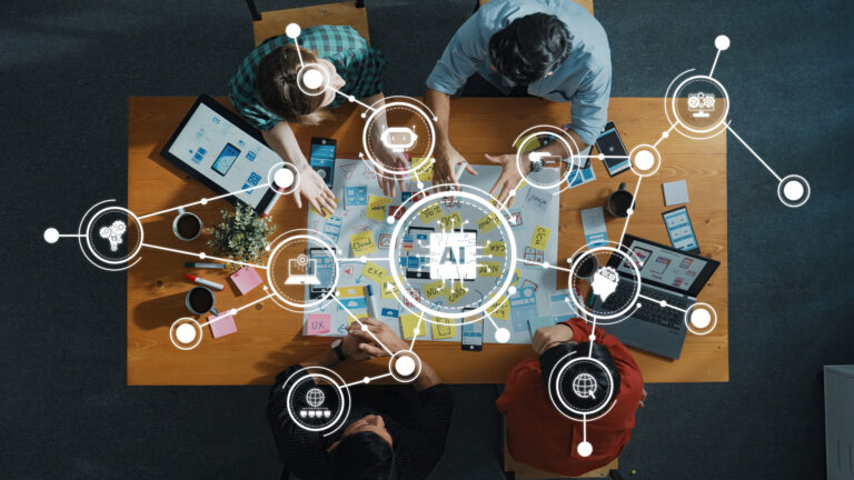 Collaborative Team Workshop Focused on AI Technology Development with Digital Tools and Ideas on a Wooden Table
